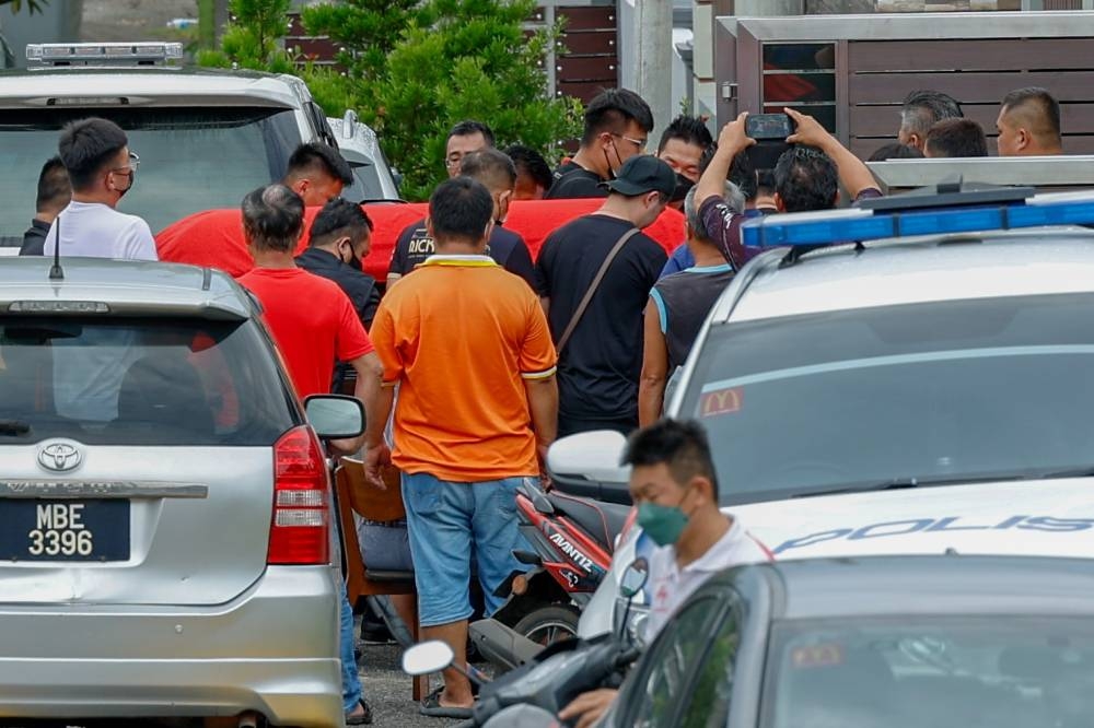 The bodies of husband and wife Lai Chee Sam, and Lai See Tin and their two-year-old son Jonas Lai Ze Kai with the ashes of their daughter Giselle Lai Yu Xi, 6, arrive at the compound of their house in Taman Machap Indah, Machap Baru in Alor Gajah, Melaka, December 22, 2022. — Bernama pic 