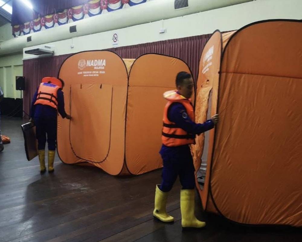 Civil Defence Force (APM) personnel sets up tents for flood victims at the Kota Samarahan Civic Centre. — Picture courtesy of Civil Defence Force