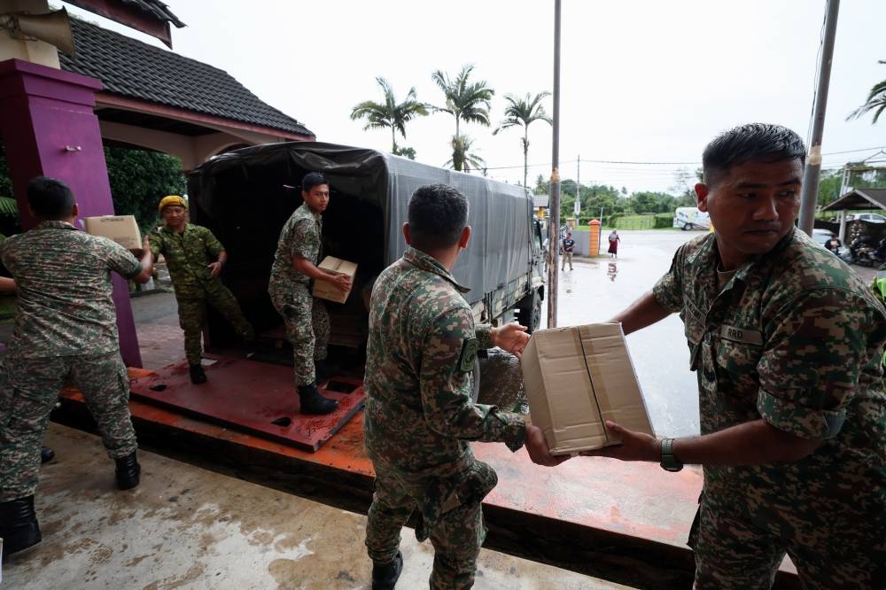 Soldiers from Regiment 512 (Territorial Soldiers) Camp Padang Midin organise daily necessities to be handed over to flood victims at the Sekolah Kebangsaan Banggol Peradong’s temporary relief centre in Kuala Terengganu, December 23, 2022. — Bernama pic 