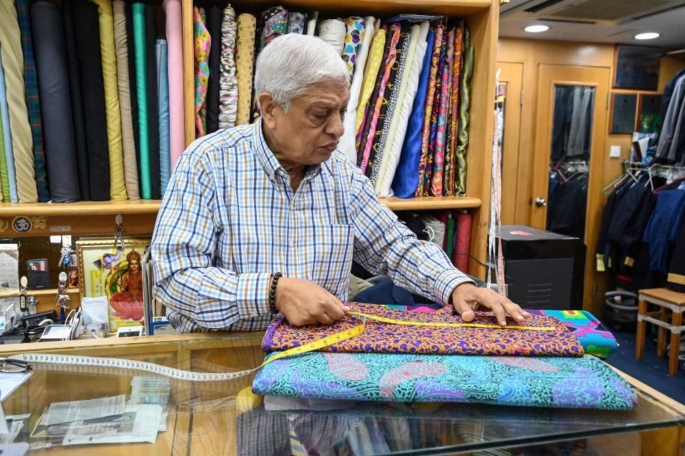 In this photo taken on October 25, 2022, Manu Melwani of Sam's Tailor works at his shop in Hong Kong. — AFP pic