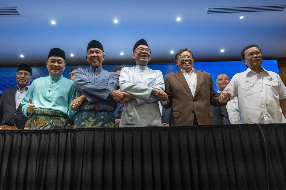 (From left) Datuk Seri Hajiji Noor, Datuk Seri Ahmad Zahid Hamidi, Datuk Seri Anwar Ibrahim, Tan Sri Datuk Patinggi Abang Abdul Rahman Johari and Datuk Seri Mohd Shafie  Apdal pose for a group photo during the national unity government agreement signing ceremony at Perdana Putra in Putrajaya December 16, 2022. — Picture by Shafwan Zaidon