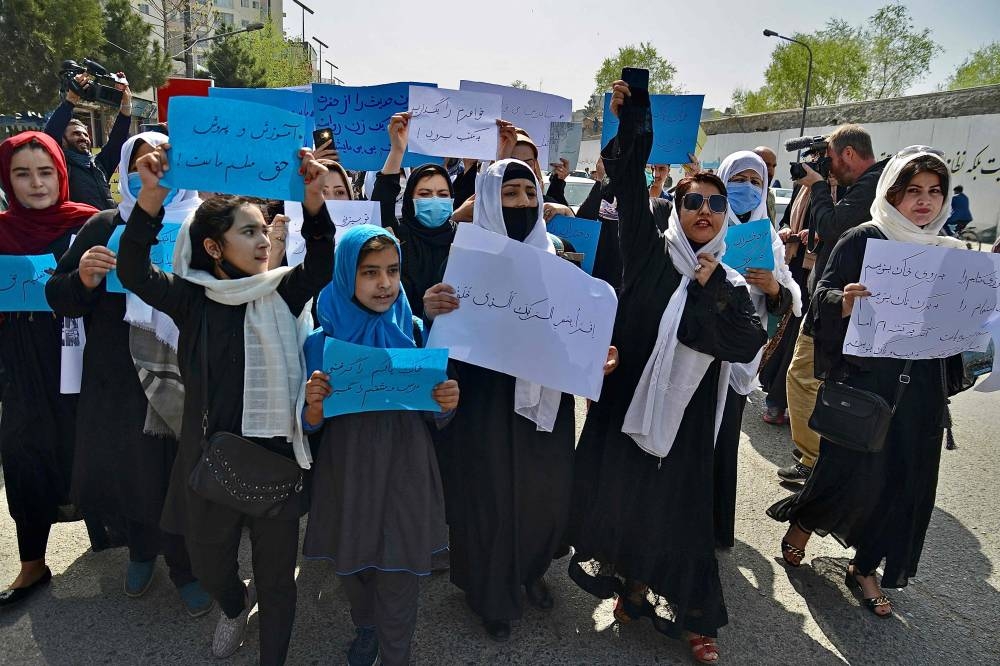 Afghan women and girls take part in a protest in front of the Ministry of Education in Kabul on March 26, 2022, demanding that high schools be reopened for girls. — AFP pic