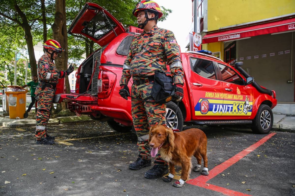 Personnel from the Selangor Fire and Rescue Department K9 Tracker Dog Unit are seen at Wisma Jakel at Section 7, Shah Alam January 2, 2023. — Picture by Yusof Mat Isa