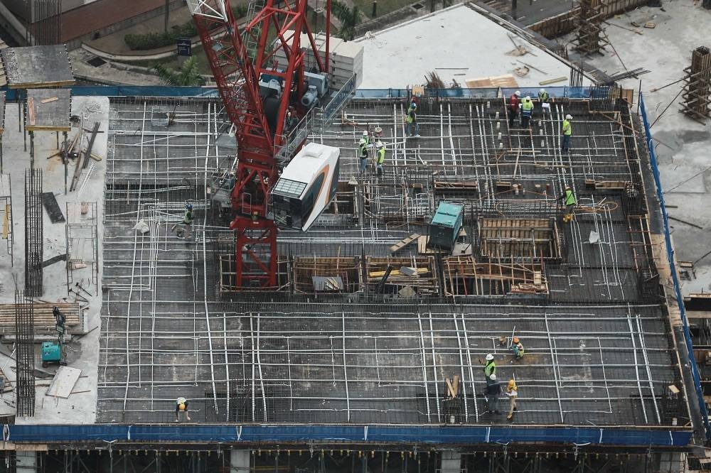 Construction workers are seen at the top of a building in Kuala Lumpur July 21, 2020. ― Picture by Ahmad Zamzahuri