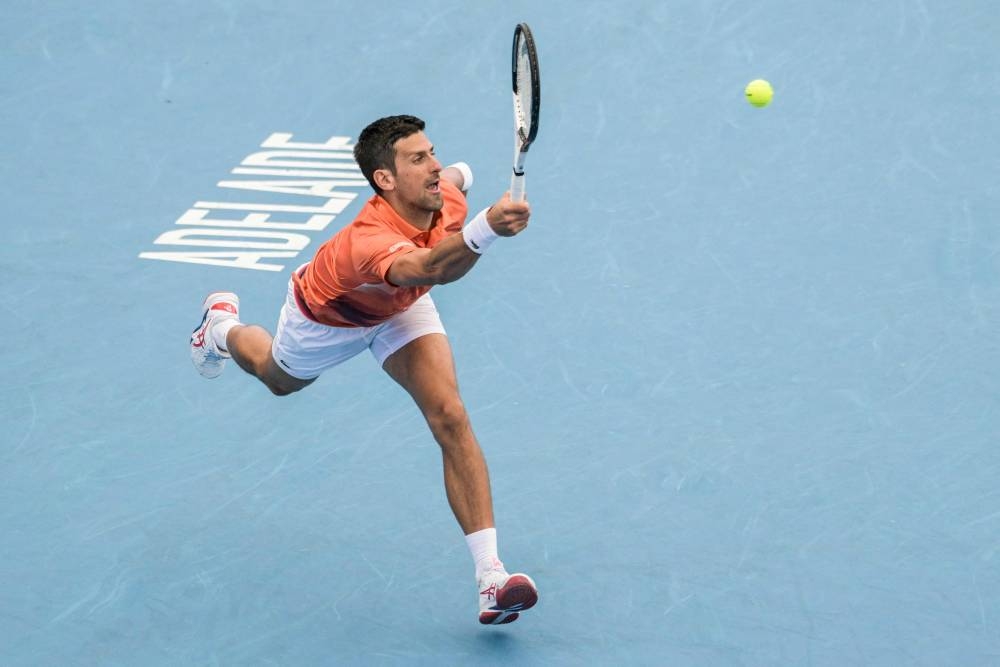 Serbia's Novak Djokovic hits a return against France's Quentin Halys during their men's singles match at the Adelaide International tennis tournament in Adelaide on January 5, 2023. — AFP pic