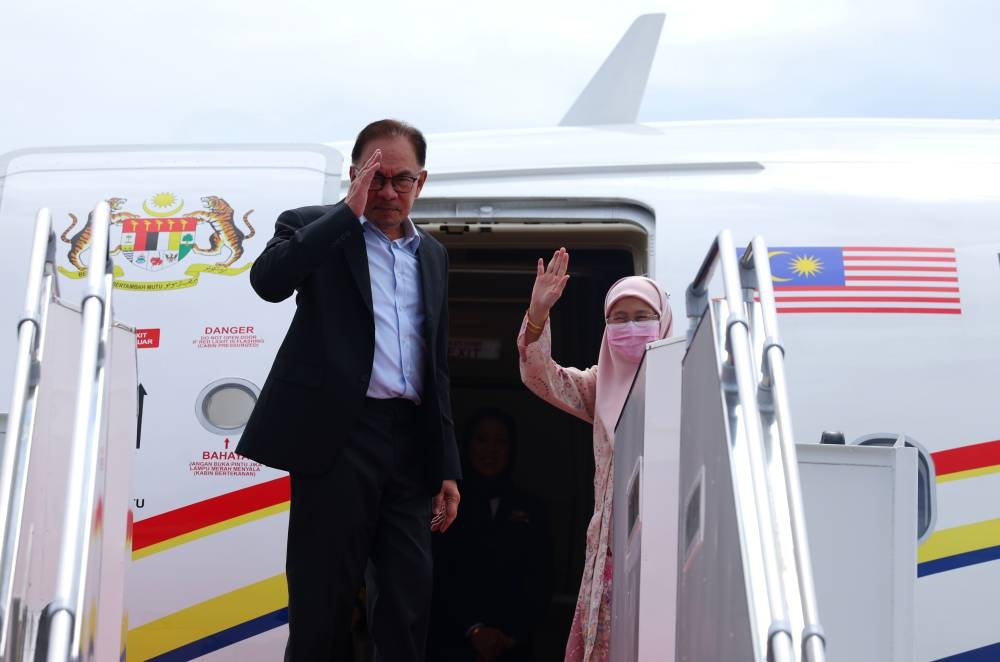 Prime Minister Datuk Seri Anwar Ibrahim and his wife Datuk Seri Dr Wan Azizah Wan Ismail wave before their flight to Jakarta at the Kuala Lumpur International Airport, Sepang January 8, 2023. — Bernama pic