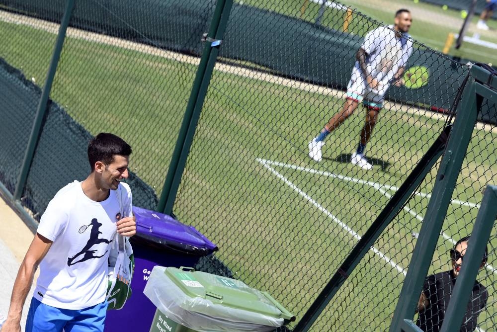 Australia's Nick Kyrgios during training as Serbia's Novak Djokovic walks past after his training, London July 9, 2022. — Reuters pic 