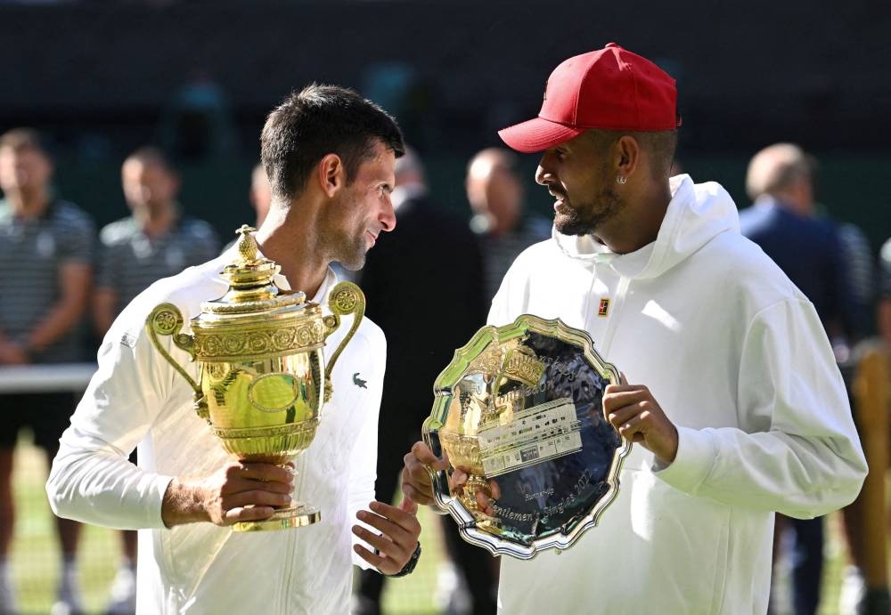 Serbia's Novak Djokovic poses with the trophy after winning the Wimbledon men's singles final alongside runner up Australia's Nick Kyrgios, July 2022. — Reuters pic