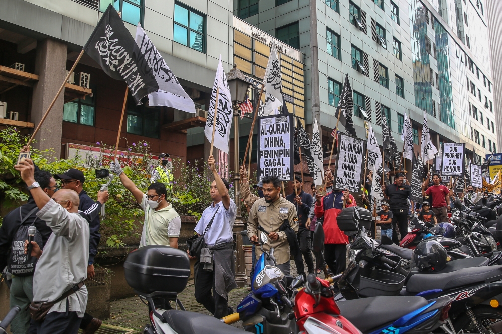 Hizbut Tahrir protesters holding placard as they march toward the  Swedish embassy during a demonstration to condemn the burning of a copy of Muslim holy book in Kuala Lumpur January 27, 2023. — Picture by Yusof Mat Isa