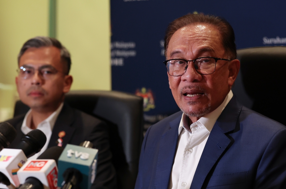 Prime Minister Datuk Seri Anwar Ibrahim holds a press conference with Malaysian media at the end of his official visit to Singapore January 30, 2023. Also present is Communications and Digital Minister Fahmi Fadzil (left). — Bernama pic 