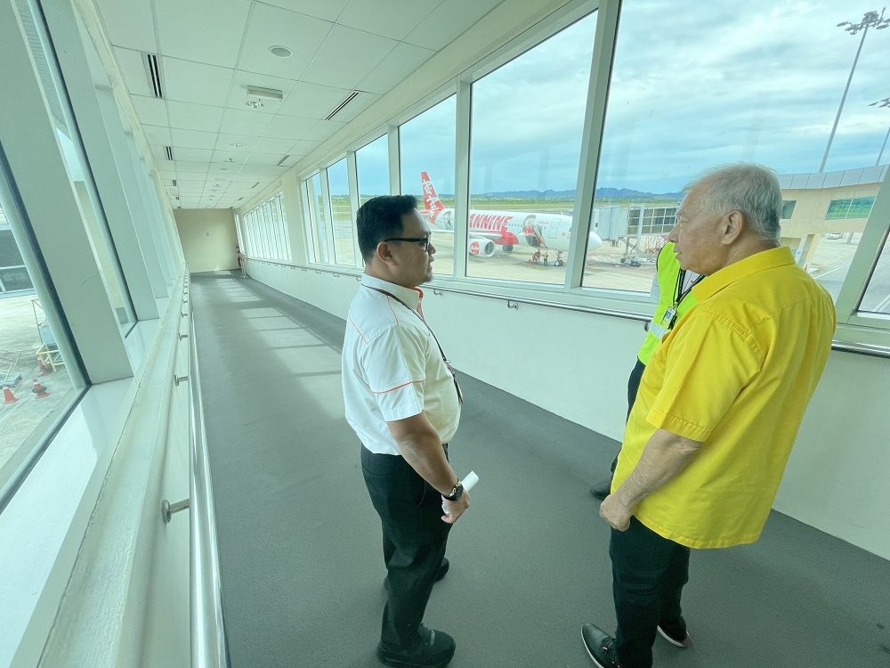 Ting (right) is briefed by an airport official during his visit. — Borneo Post Online pic