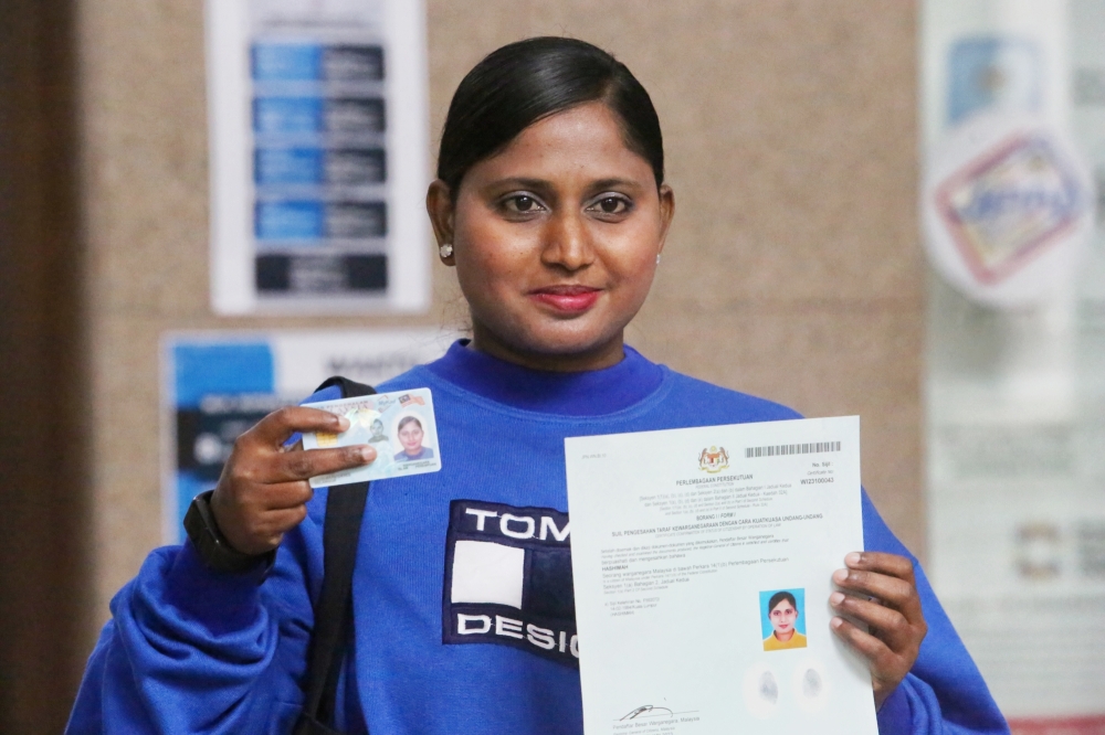 Hashimah holding her new blue MyKad and citizenship certificate at the National Registration Department in Putrajaya February 3, 2023. ― Picture by Choo Choy May