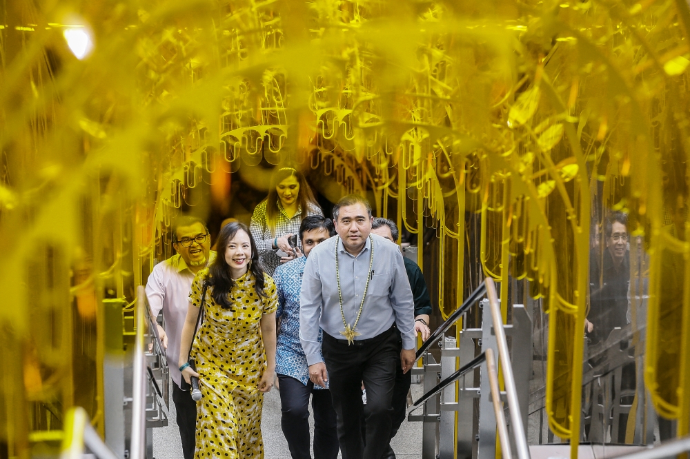 Artist Pamela Tan (left) accompanies Transport Minister Anthony Loke as he examines her Sunnyside Up installation for Arts on the Move, at the Pasar Seni MRT Station in Kuala Lumpur on February 14, 2023. — Picture by Hari Anggara