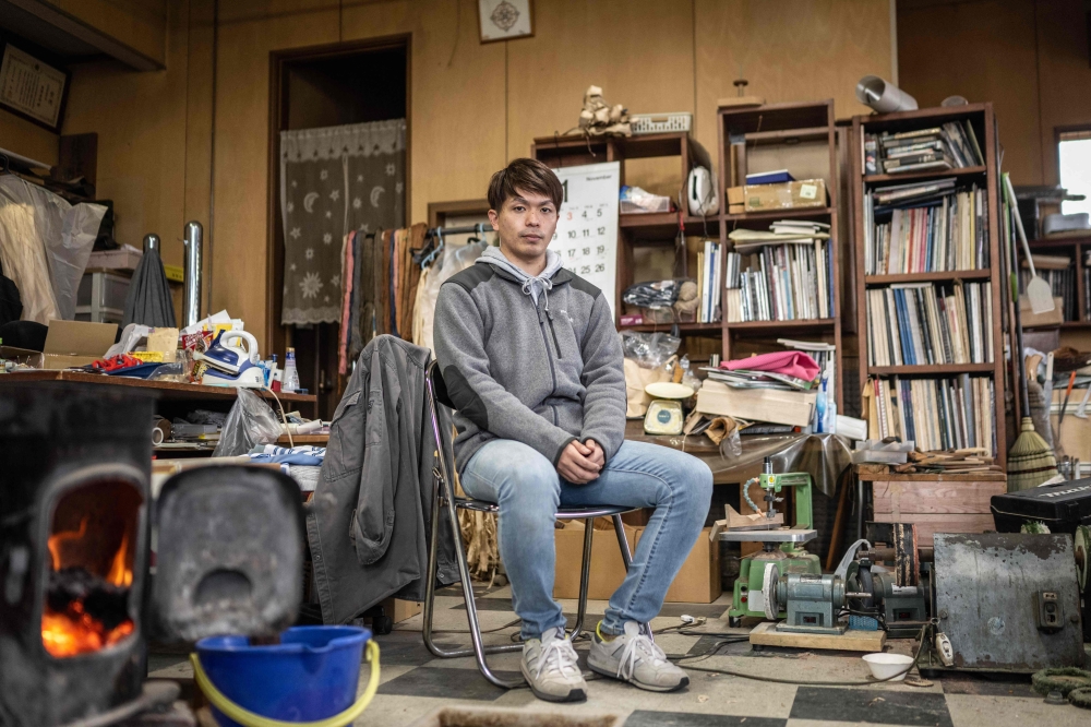 Tomoya Okamoto of the Ainu Indigenous group and apprentice sculptor poses for photographs at his teacher's workshop in Biratori, in northern Japan's Hokkaido November 17, 2022. — AFP pic