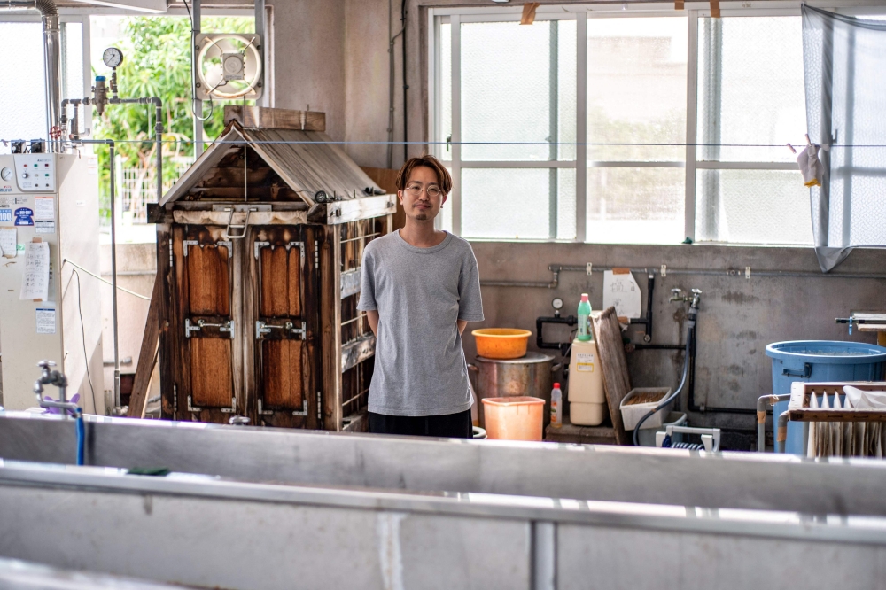 Artisan Toma Chinen, who inherited the workshop of one of three Bingata-making families that once served Ryukyu royalty, posing at his shop in Naha, in Japan's Okinawa Prefecture August 22, 2022. — AFP pic