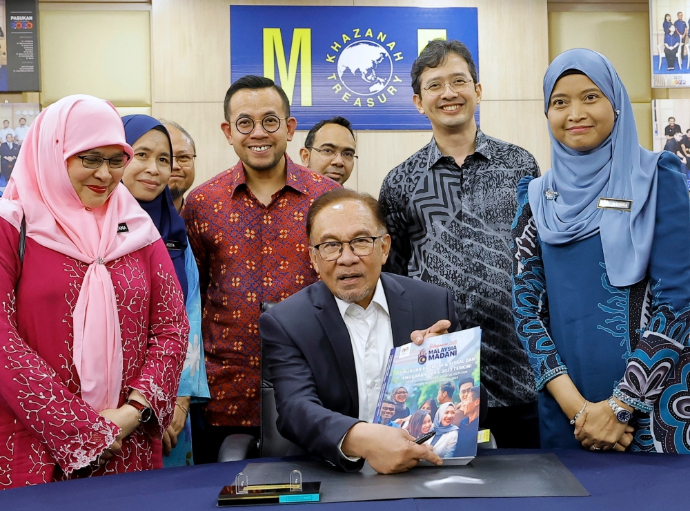 Prime Minister who is also Finance Minister Datuk Seri Anwar Ibrahim showing the Malaysia Madani book when he was present to review the final preparations for Budget 2023 at the Finance Ministry, Putrajaya, February 23, 2023. — Bernama pic