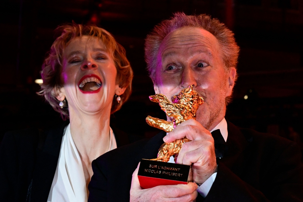 French director Nicolas Philibert (right) poses with the ‘Golden Bear for Best Film’ for the film ‘Sur l'Adamant’ (On the Adamant)  after the awards ceremony of the 73rd Berlin International Film Festival Berlinale in Berlin February 25, 2023. — AFP pic