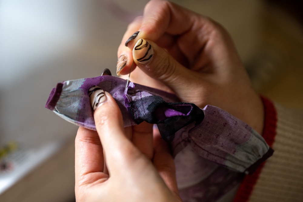 This photo taken on January 24, 2023 shows Ryoko Baba, a 33-year-old graphic designer, sewing a costume for her Licca-chan dolls at home in Tarui, Gifu Prefecture. — AFP pic