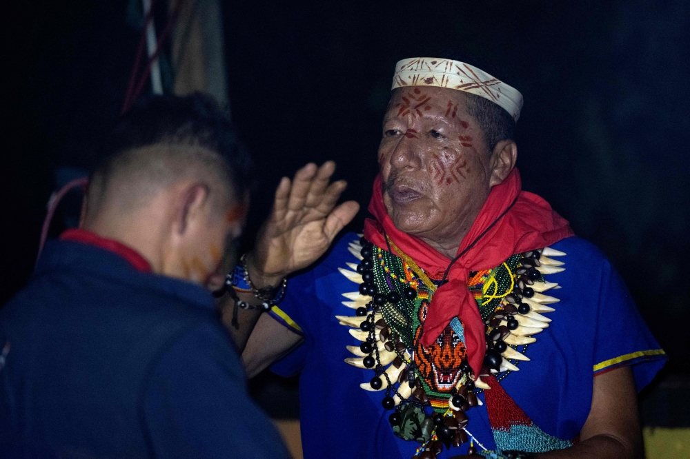 Isidro Lucitante (right), a healer of the indigenous Cofan ethnic group, takes part in a Yage (Ayahuasca) drinking ceremony in Avie village, in Lago Agrio, Sucumbos Province, Amazon region, Ecuador January 14, 2023. — AFP pic