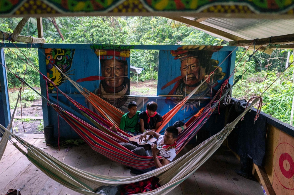 Members of the indigenous Cofan ethnic group rest in hammocks during a Yage (Ayahuasca) drinking ceremony at Avie village, in Lago Agrio, Sucumbيos Province, Amazon region, Ecuador January 14, 2023. — AFP pic