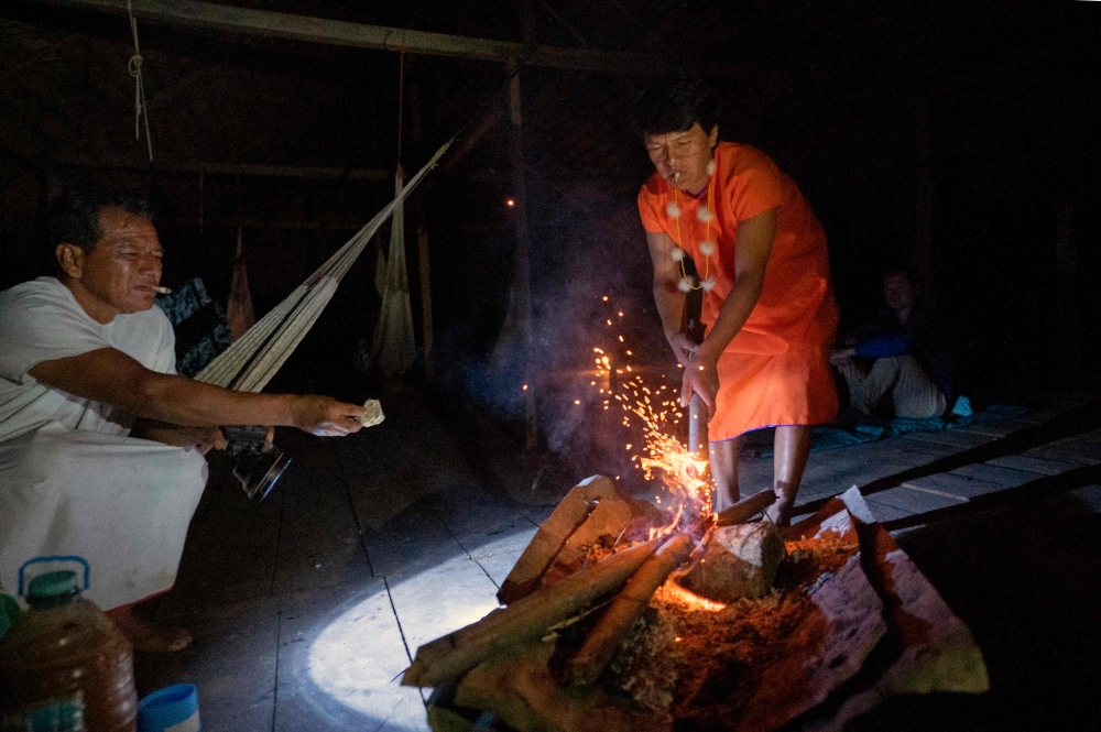 Miguel Payaguaje (left), healer of the indigenous Siekopai ethnic group (Multicoloured people), and an assistant take part in a Yage (Ayahuasca) drinking ceremony in Lagartococha, Maٌoco, Amazon region, Peru, on January 11, 2023. — AFP pic