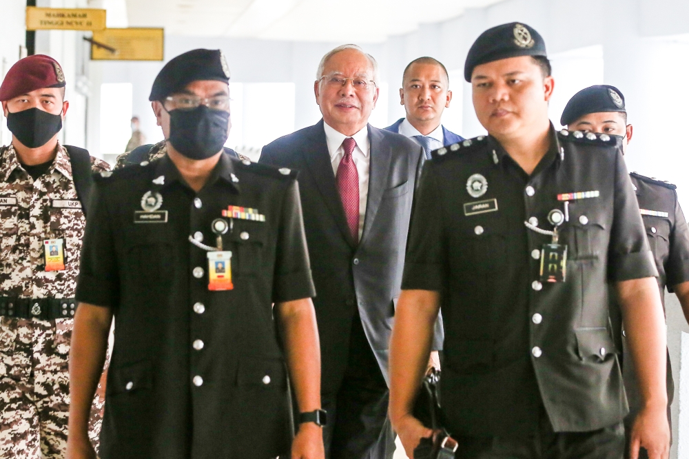 Police escort former prime minister Datuk Seri Najib Razak (centre) to a hearing at the Kuala Lumpur Court Complex on March 1, 2023. — Picture by Yusof Mat Isa