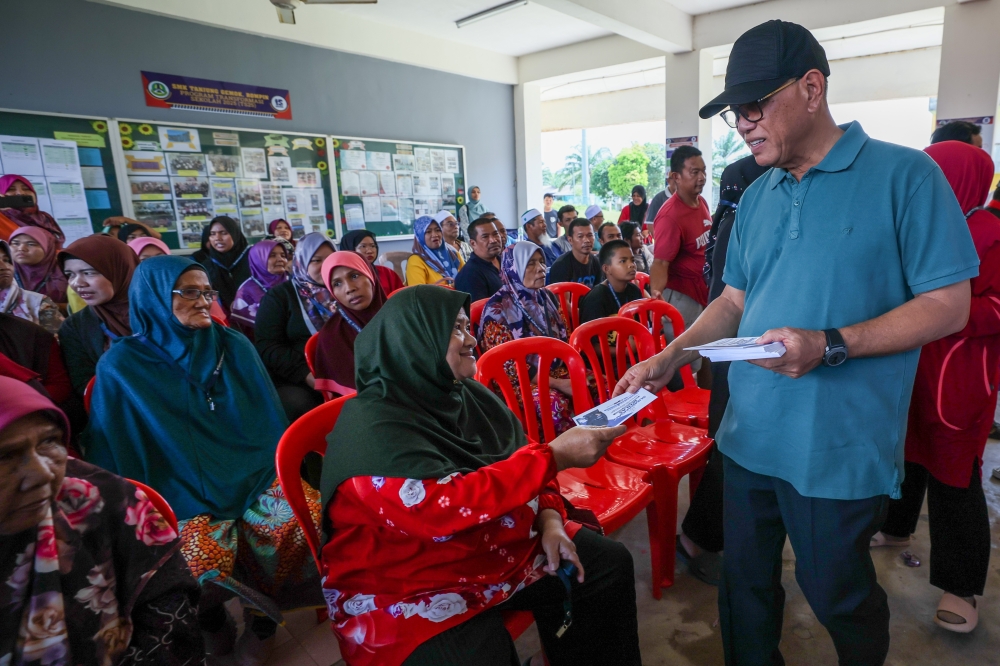 Pahang Menteri Besar Datuk Seri Wan Rosdy Wan Ismail hands out aid to flood victims during a visit to the relief centre at Sekolah Menengah Kebangsaan (SMK) Tanjung Gemok, Rompin March 6, 2023. — Bernama pic