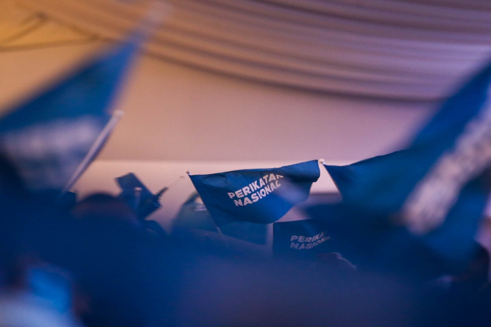 Perikatan Nasional (PN) party members weaving PN flags during the announcement of the candidates for the coalition’s Johor state election at Pulai Springs Resort,Johor February 24, 2022. — Picture by Hari Anggara