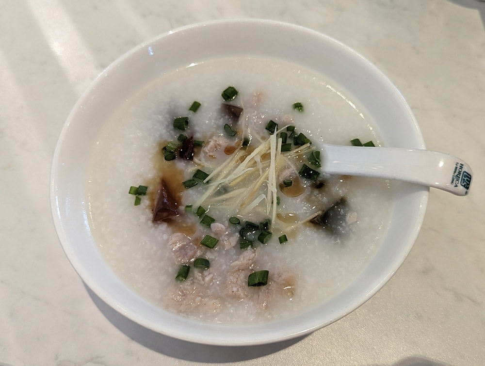 In classic Cantonese style, the century egg and pork porridge is silky smooth, and the lean slices of pork are incredibly tender.