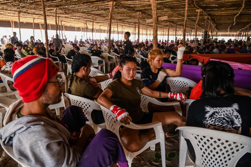 This photo taken on March 4, 2023 shows female fighters of the Karen state Border Guard Force waiting for their bouts in a traditional Myanmar boxing Lethwei tournament at Pyi Thar Lin Aye pagoda in Hlaingbwe township in Karen state. — AFP pic