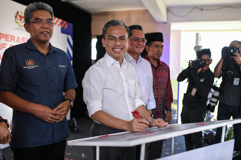 Communications and Digital Minister Fahmi Fadzil signs a plaque during the opening the Northern Zone fibre optic PoP hub in SMK Padang Terap March 29, 2023. — Bernama pic