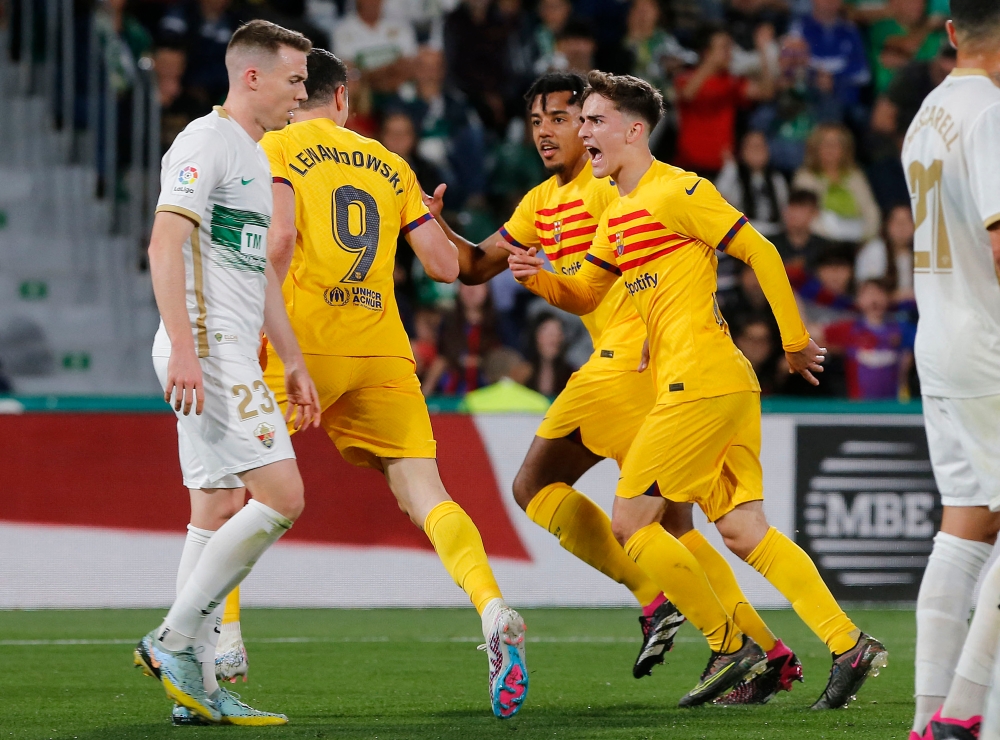 Barcelona's Polish forward Robert Lewandowski celebrates scoring the opening goal with Barcelona's Spanish midfielder Gavi (right) and Barcelona's French defender Jules Kounde during the Spanish league football match between Elche CF and FC Barcelona at the Martinez Valero stadium in Elche on April 1, 2023. — AFP pic