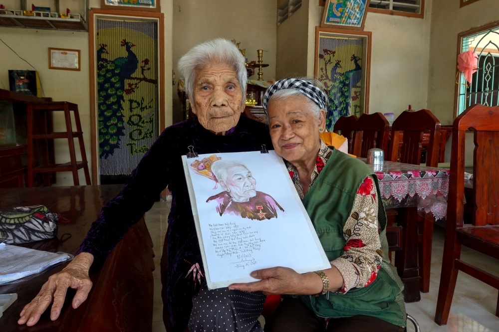 Vietnamese artist, Dang Ai Viet, poses with a woman she painted as a part of her project, 