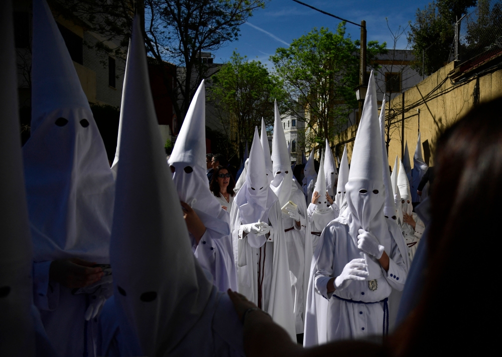 Penitents of La Paz brotherhood gather at the church prior to participating in the Palm Sunday procession, in Seville on April 2, 2023. — AFP pic