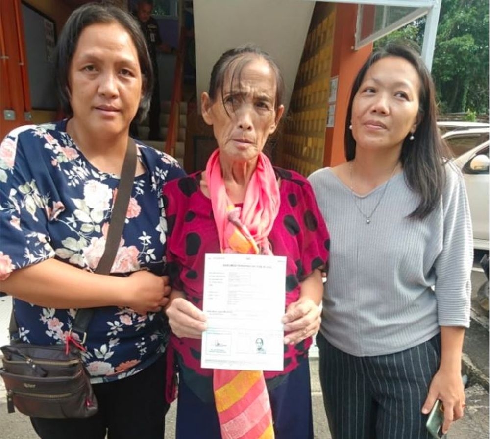 Lina (centre) holding a temporary identification document issued by JPN in Lawas yesterday with Ruran (left) and Agnes. — Borneo Post pic