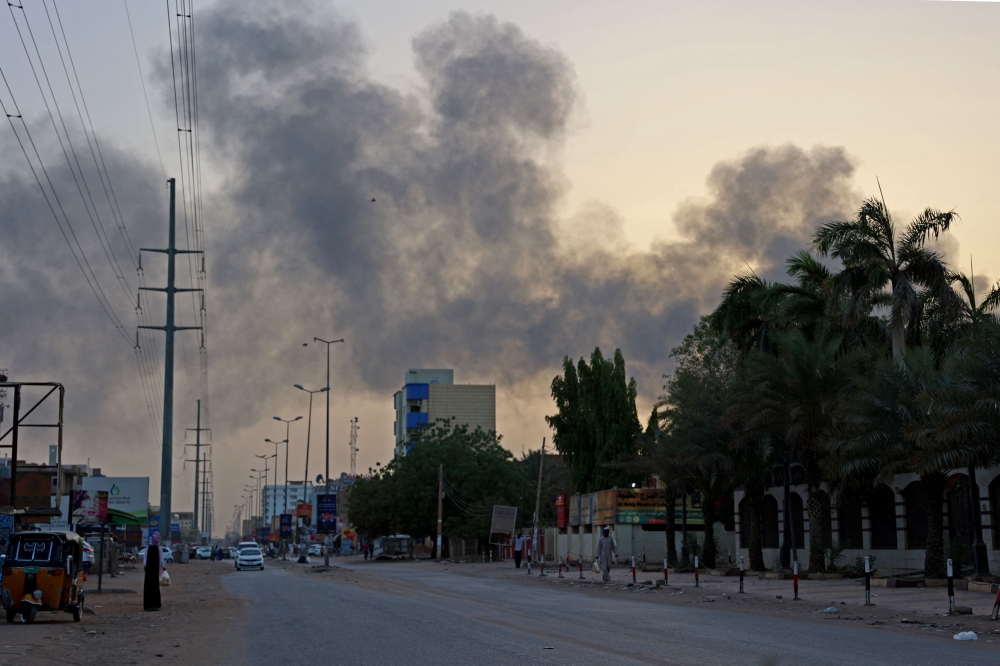 Smoke billows above residential buildings in east Khartoum on April 16, 2023, as fighting in Sudan raged for a second day in battles between rival generals. — AFP pic