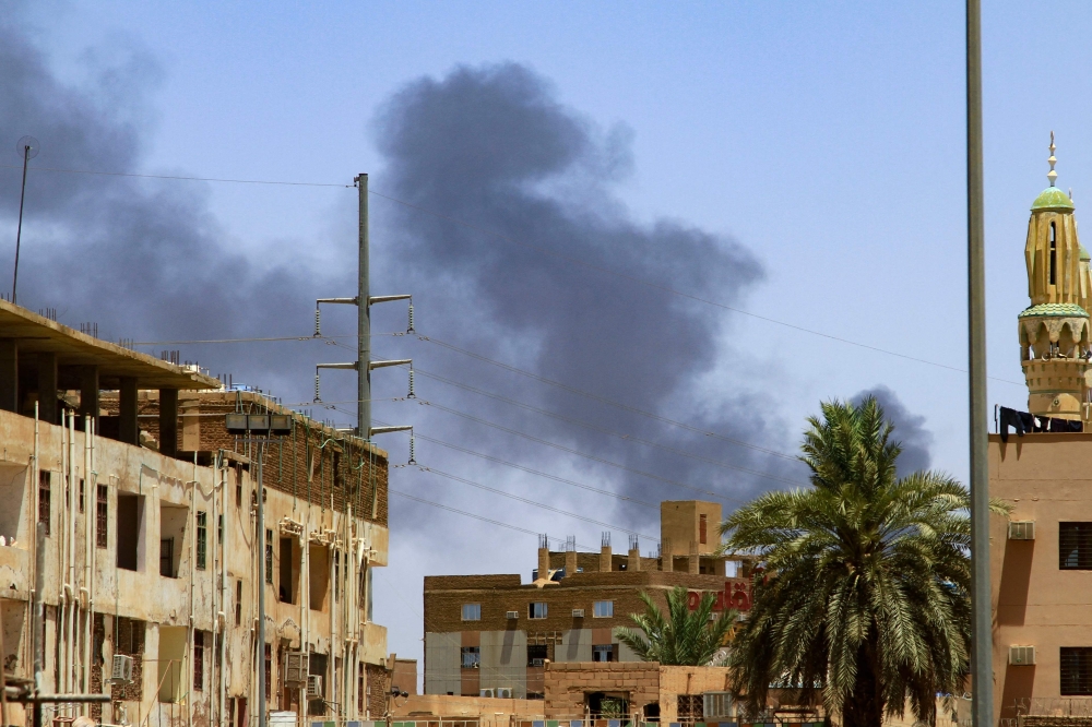 Smoke rises behind buildings in Khartoum on April 19, 2023, as fighting between the army and paramilitaries raged for a fifth day after a 24-hour truce collapsed. — AFP pic