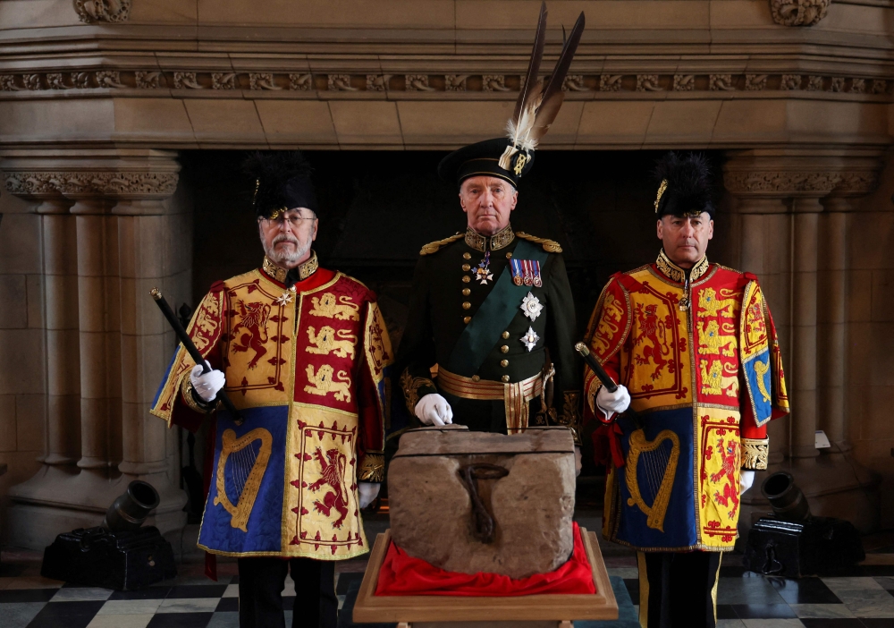 The Duke of Buccleuch Richard Scott (centre), flanked by two Officers of Arms, stands by the Stone of Destiny during a special ceremony at Edinburgh Castle on April 27, 2023 before it is transported to Westminster Abbey for the Coronation of Britain's King Charles III. — Russell Cheyne/Pool /AFP pic