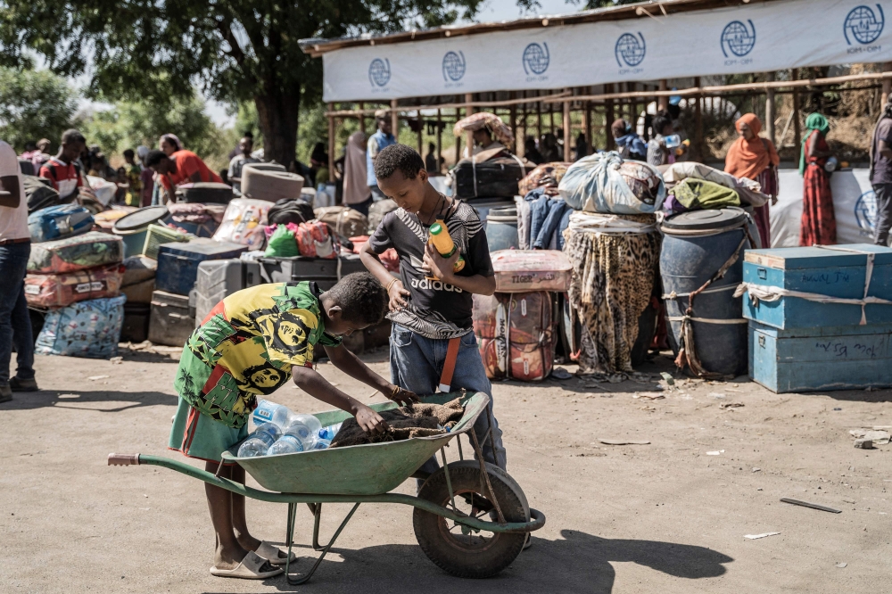 A young boy sells a drinks to refugees from Sudan who crossed into Ethiopia in Metema, on May 4, 2023. More than 15,000 people have fled Sudan via Metema since fighting broke out in Khartoum in mid-April, according to the UN’s International Organization for Migration, with around a thousand arrivals registered per day on average. — AFP pic