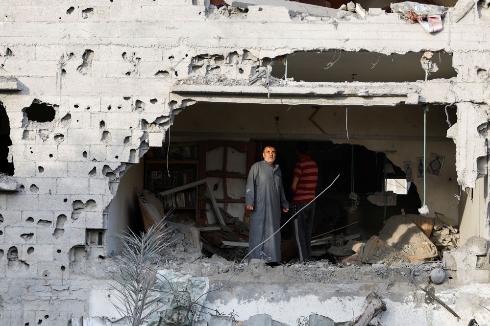 Palestinians gather at the site of an Israeli airstrike amid Israel-Gaza fighting in Deir al-Balah town in the central Gaza Strip, May 13, 2023. — Reuters pic