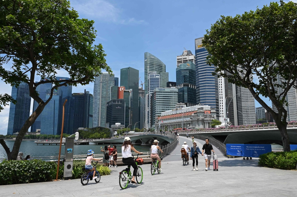 In this file photo taken on April 24, 2023 people walk across Jubilee Bridge at Marina Bay in Singapore. — AFP pic