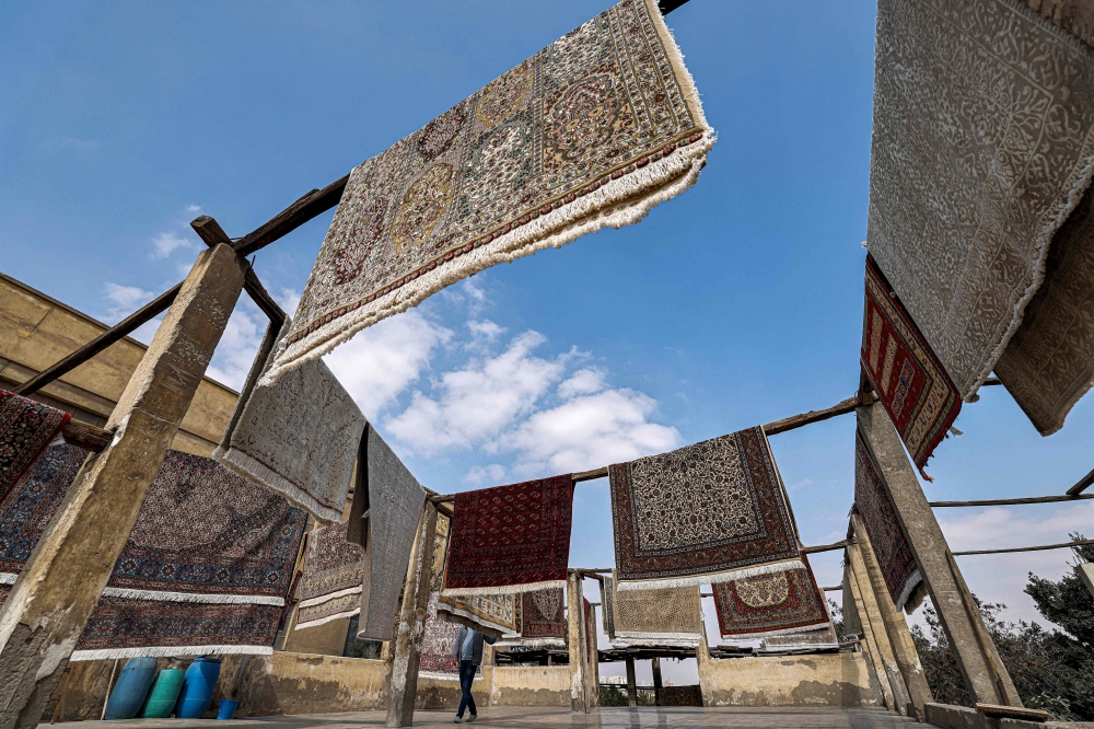 In this picture taken on February 20, 2023 finished rugs are hung out to dry at the Kahhal looms hand-made rugs workshop in the Basatin district of Cairo. — AFP pic