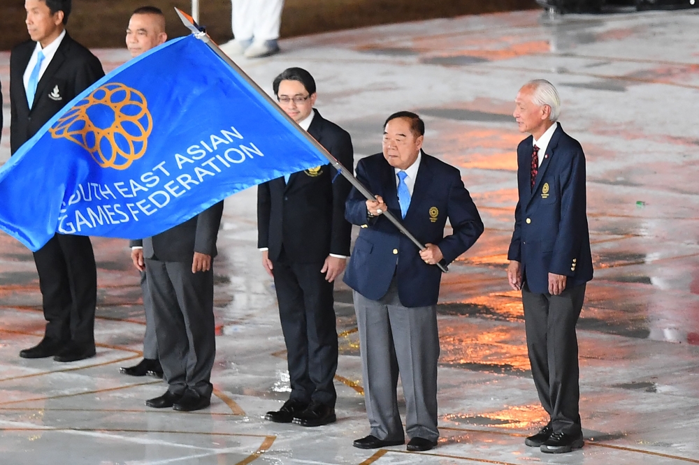 Thailand's Deputy Prime Minister Prawit Wongsuwan (2nd right) waves the South East Asian Games Federation flag at the closing ceremony of the 32nd South-east Asian Games (SEA Games) at the Morodok Techo National Stadium in Phnom Penh on May 17, 2023, with Thailand due to take over as host at the next SEA Games. — AFP pic