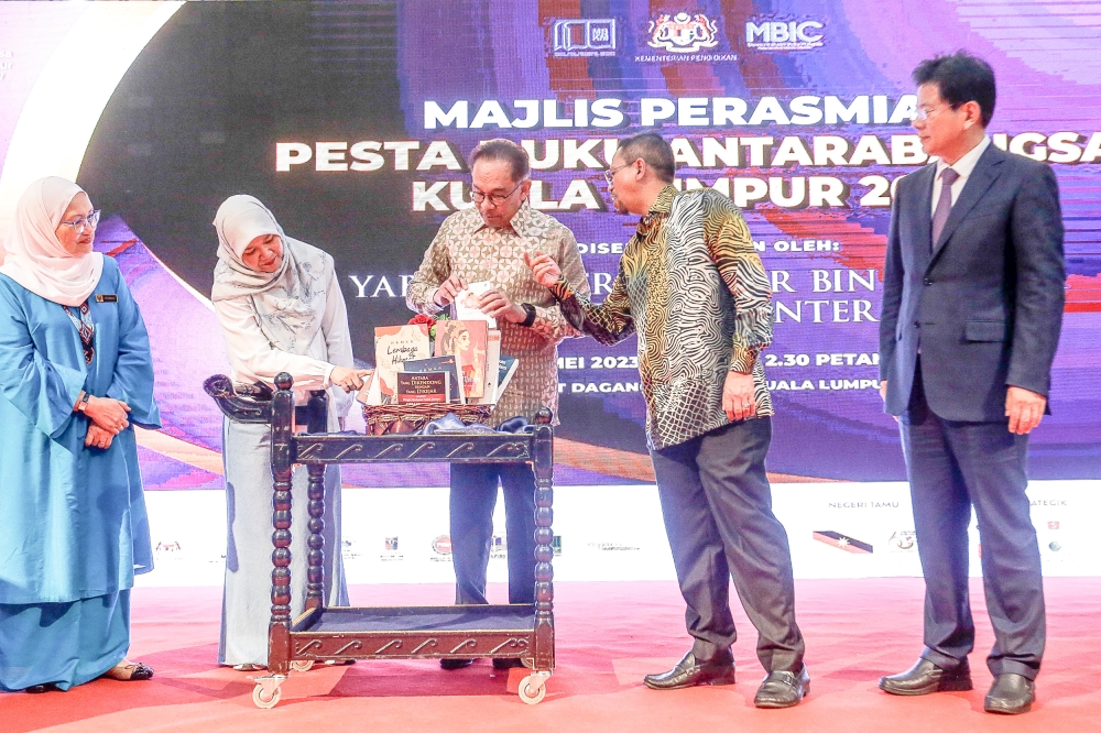 Prime Minister Datuk Seri Anwar Ibrahim (centre) looks at several books on display during the launch of the Kuala Lumpur International Book Festival at Putra World Trade Centre, Kuala Lumpur May 27, 2023. — Picture by Sayuti Zainudin