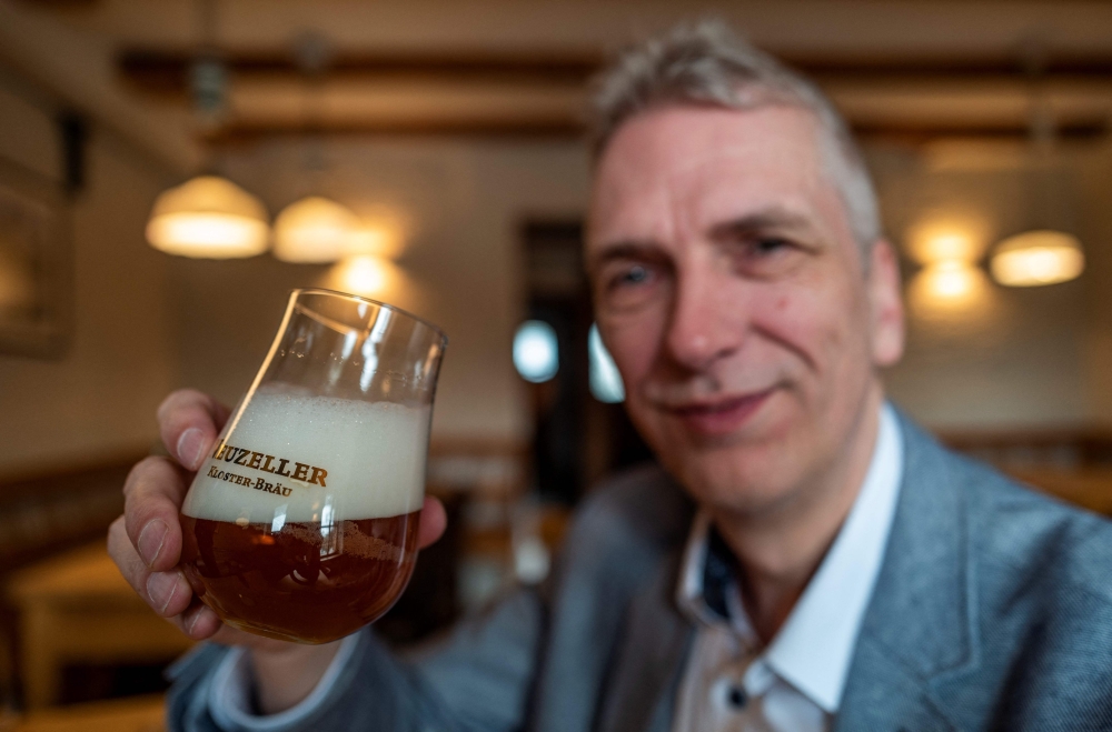 With its golden hue, bittersweet notes and frothy head, Stefan Fritsche's latest brew looks and tastes like any other beer. — AFP pic