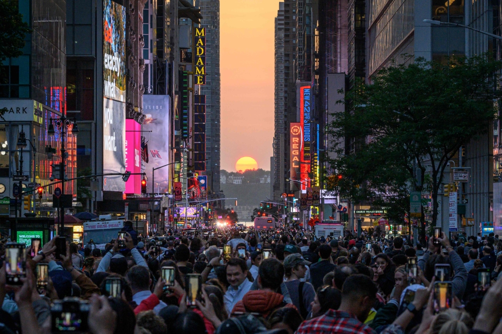 The Sun sets in alignment with Manhattan streets running east-west, also known as Manhattanhenge, in New York City on May 30, 2023. Manhattanhenge occurs about the same two days in May and then again on two days in July every year. — AFP pic