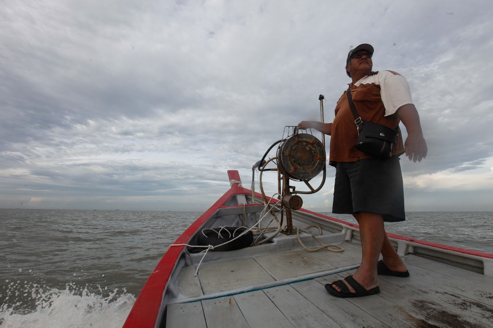 Lim Kee Hwa at the deck of the fishing boat. — Picture by Sayuti Zainudin