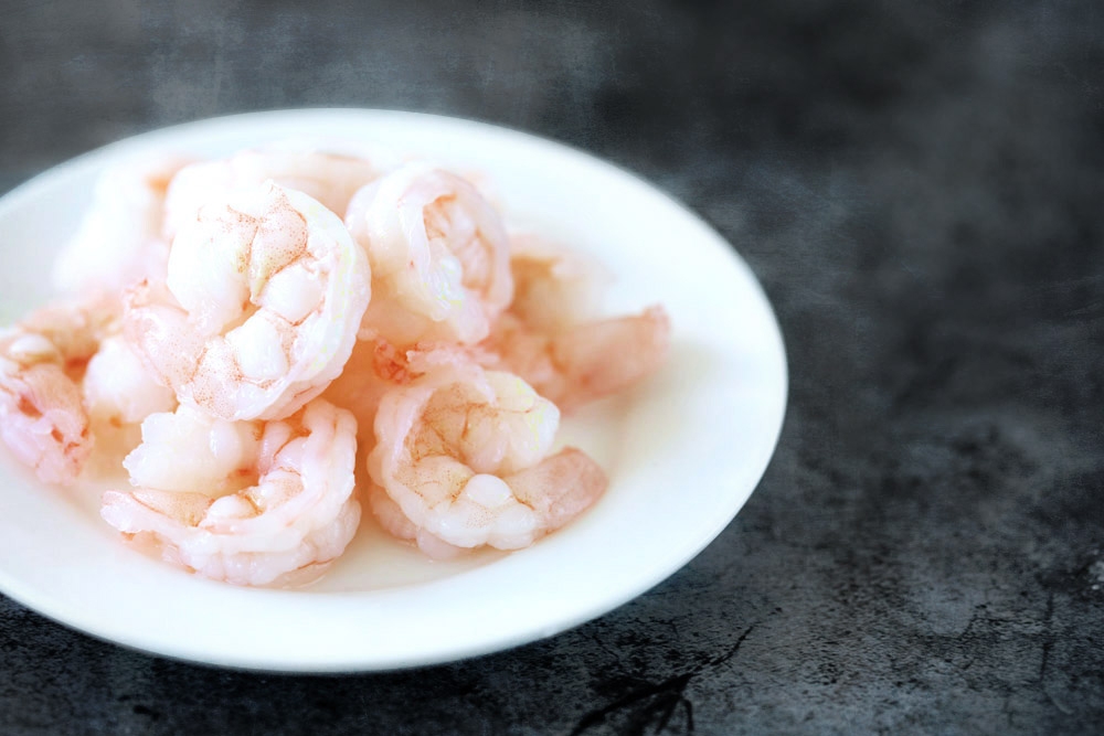 The use of prawns complement the squid ink pasta for a seafood theme.