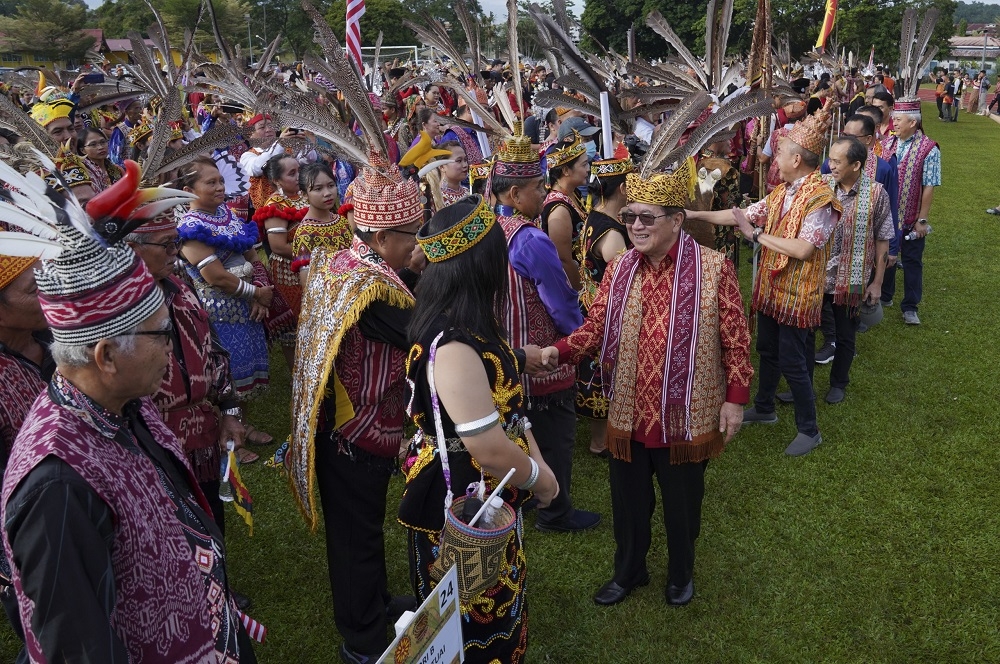 Uggah (front, right) greets parade participants. — Borneo Post Online pic