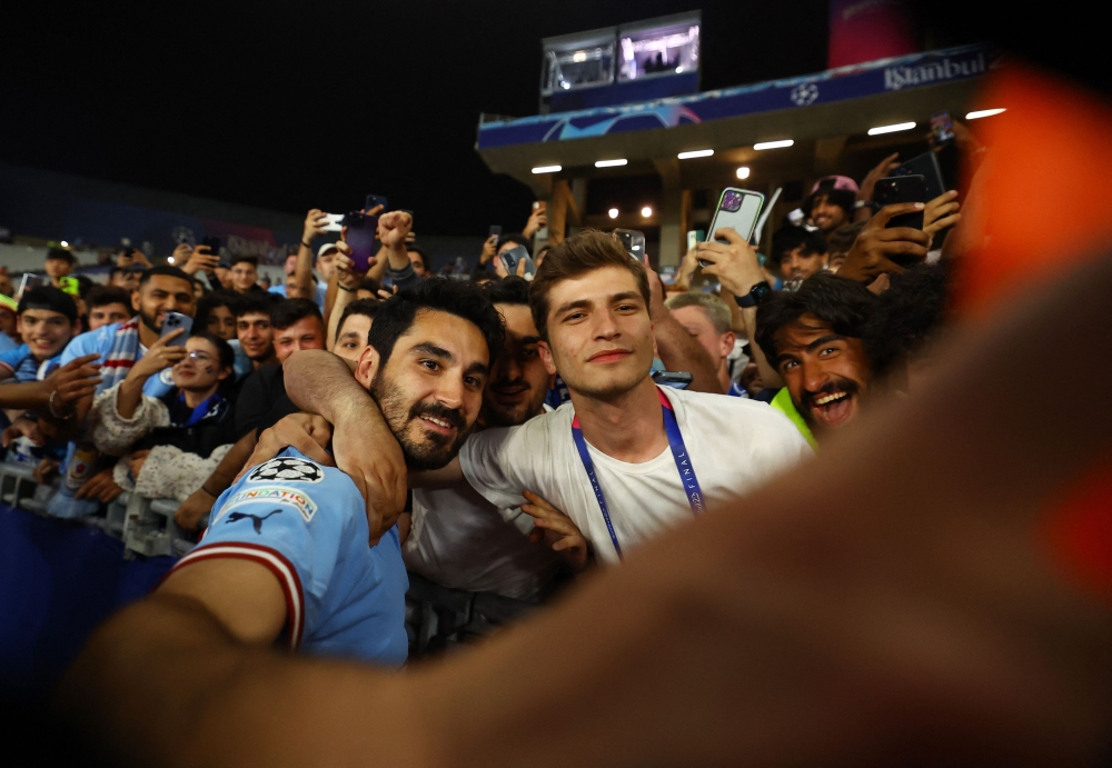 Manchester City's Ilkay Gundogan celebrates with fans after winning the Champions League at the Ataturk Olympic Stadium, Istanbul June 11, 2023. — Reuters pic